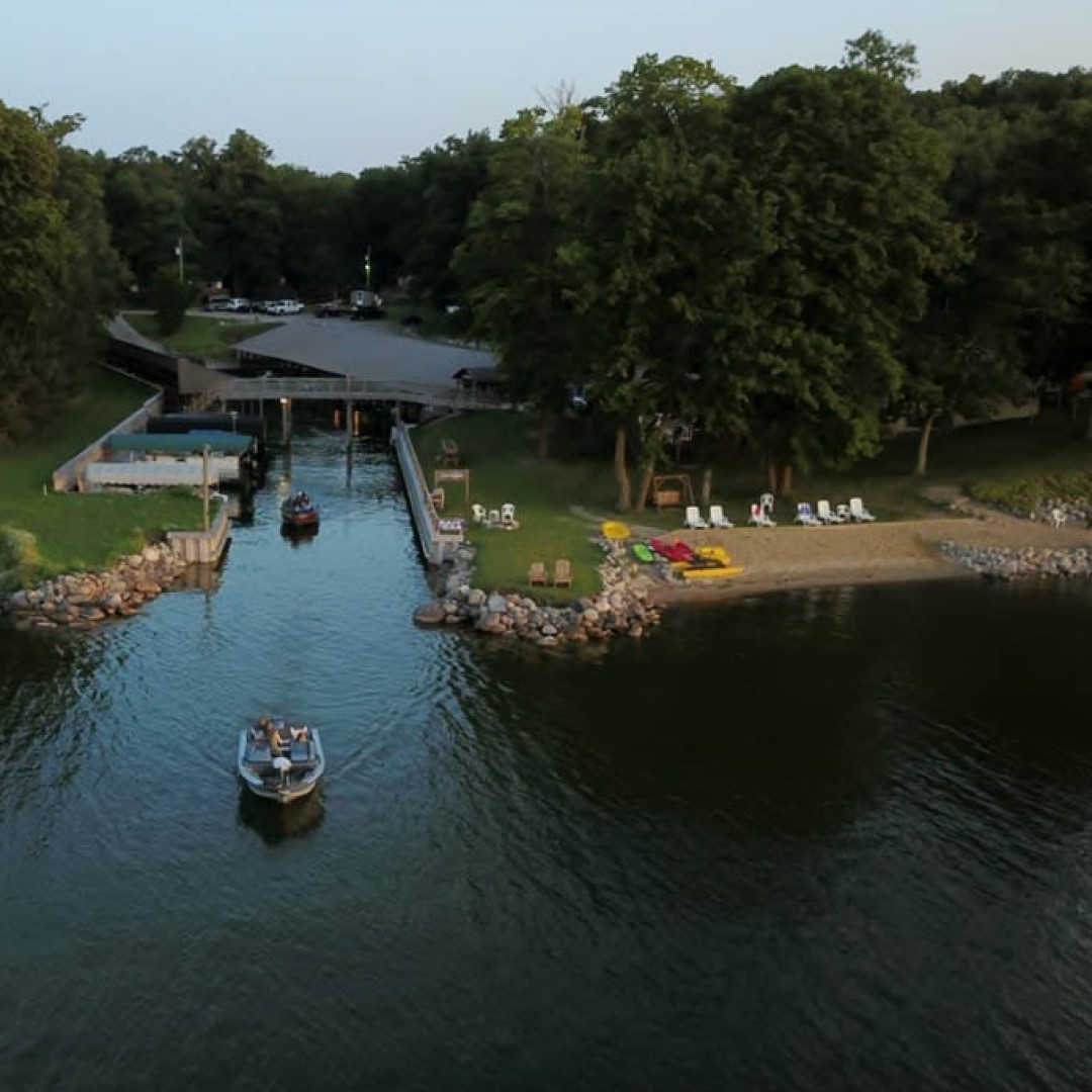 A boat coming out to the open lake of covered inland harbor that offers dock rental on Leech Lake MN