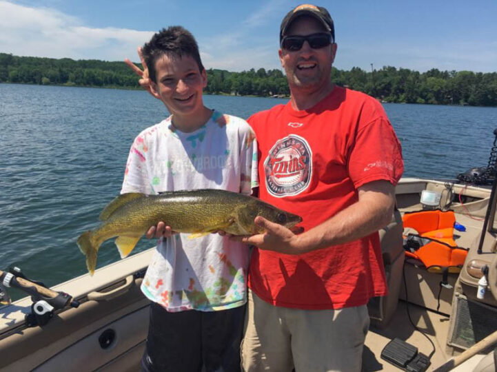 Dad and son holding walleye while fishing on Leech Lake