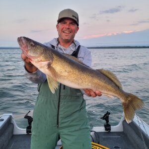 Spring Fishing holding a large walleye in boat on Leech Lake.